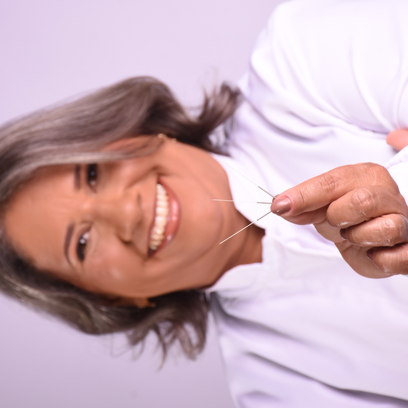 Renata Sanches segurando agulhas finas de acupuntura
